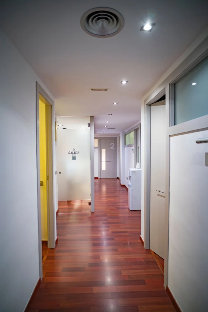 Pasillo interior de la clínica dental Gutiérrez Odontólogos en Almería, acceso a gabinetes y salida señalizada
