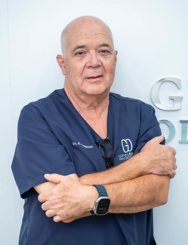 Antonio Gutiérrez Márquez, director médico de la clínica dental Gutiérrez Odontólogos en Almería, especialista en cirugía oral, implantología y endodoncia, posando con uniforme clínico azul marino