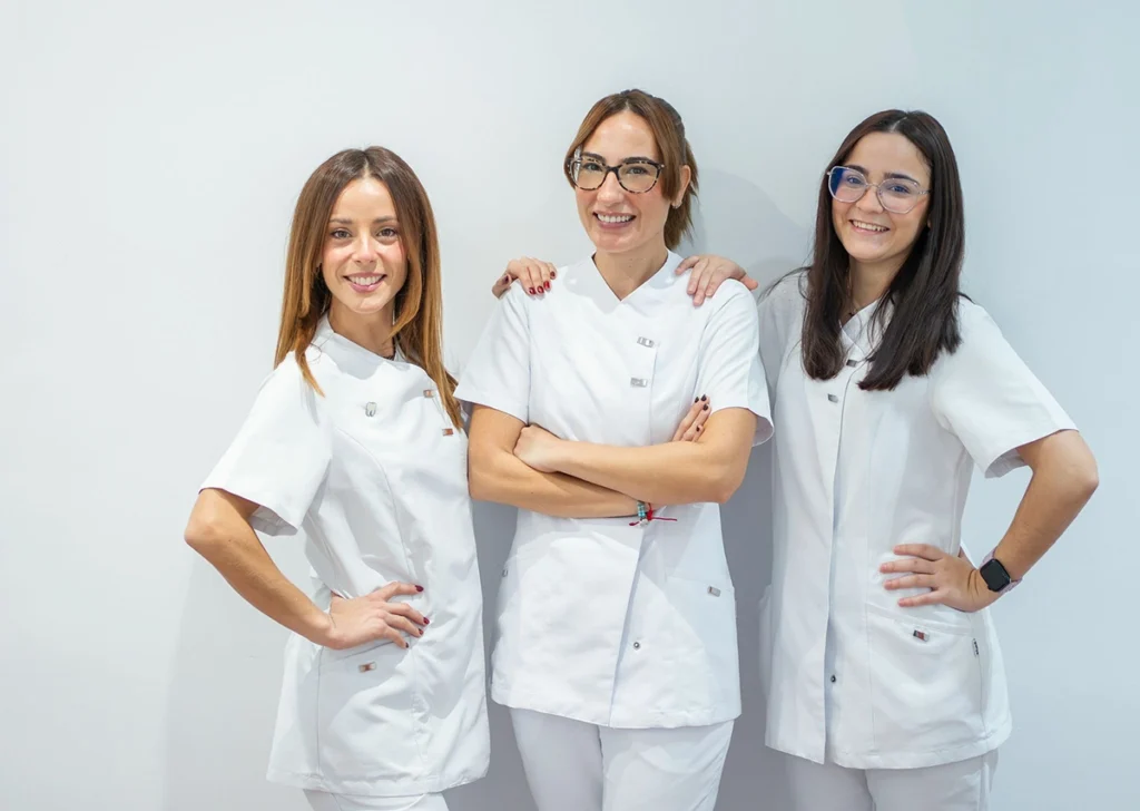 Equipo de auxiliares de ortodoncia de la clínica dental Gutiérrez Odontólogos en Almería, dentistas con reseñas destacadas, posando con uniformes blancos