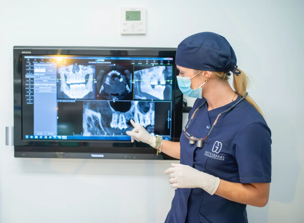 Dentista en Almería de la clínica Gutiérrez Odontólogos señala una radiografía 3D para explicar los principales síntomas de la enfermedad periodontal, como sangrado de encías y movilidad dental